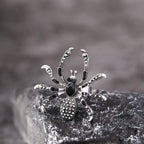 Blackwidow Spider rings with silver engraved legs and black gem body displayed on rock