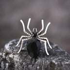 Blackwidow Spider rings with silver legs and faceted black gemstone on textured stone