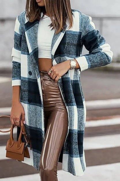 Woman wearing a blue and white plaid wool coat paired with brown leather pants, a white crop top, and a tan handbag.