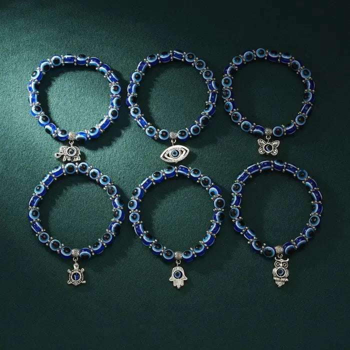 Set of six blue evil eye bracelets with silver charms for Turkish protection and spiritual energy.
