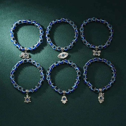 Set of six blue evil eye bracelets with silver charms for Turkish protection and spiritual energy.