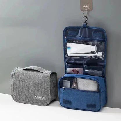 Blue hanging toiletry bag open with gray closed organizer beside it on white surface