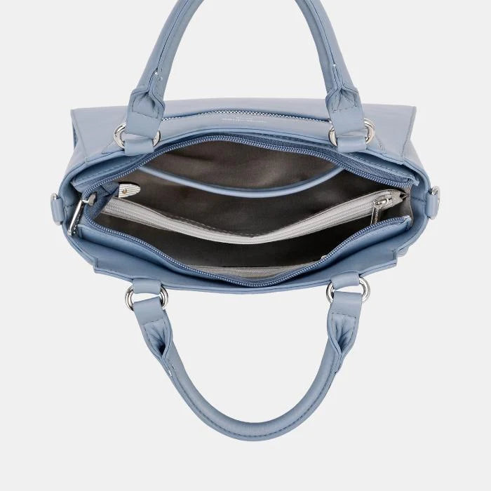 Open view showing multi-compartment interior of blue leather handbag with fabric lining