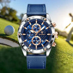 High-end leather watch with a blue strap, rose gold details, and chronograph design, set against a golf course background.