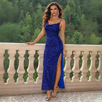 Blue prom dress with sequins featured on elegant stone balcony overlooking lush green forest, showcasing formal evening style.