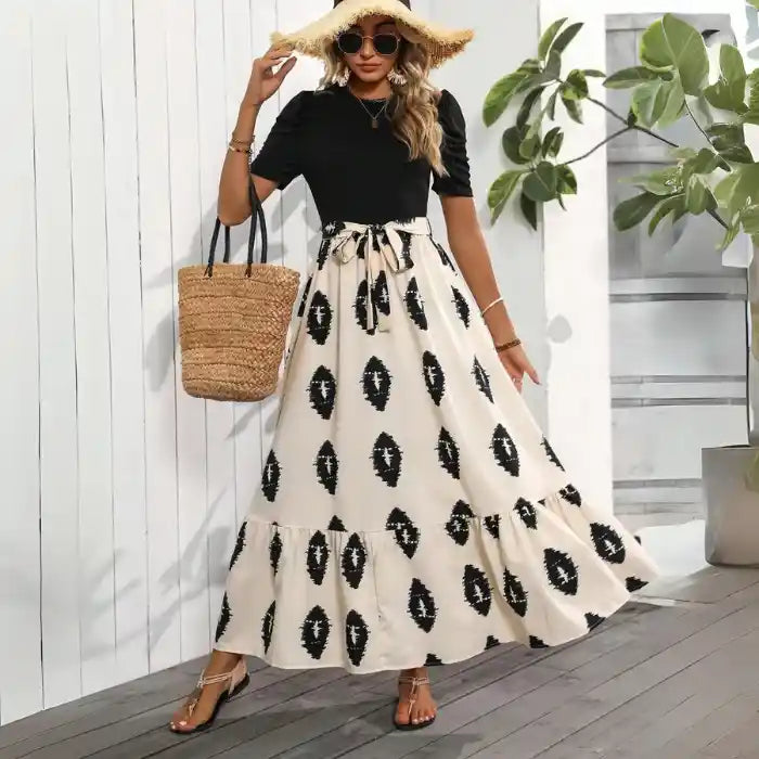 Boho maxi dress black beige summer look accessorized with straw tote and sun hat for a chic beach day.