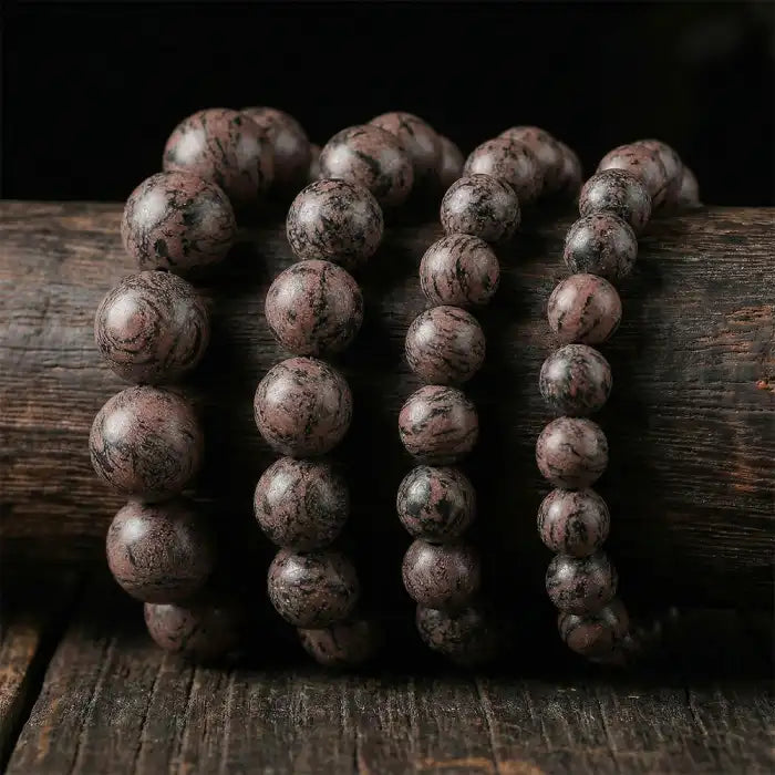 Botanical scented beaded bracelet herbal featuring brown marbled beads arranged on rustic wood surface.