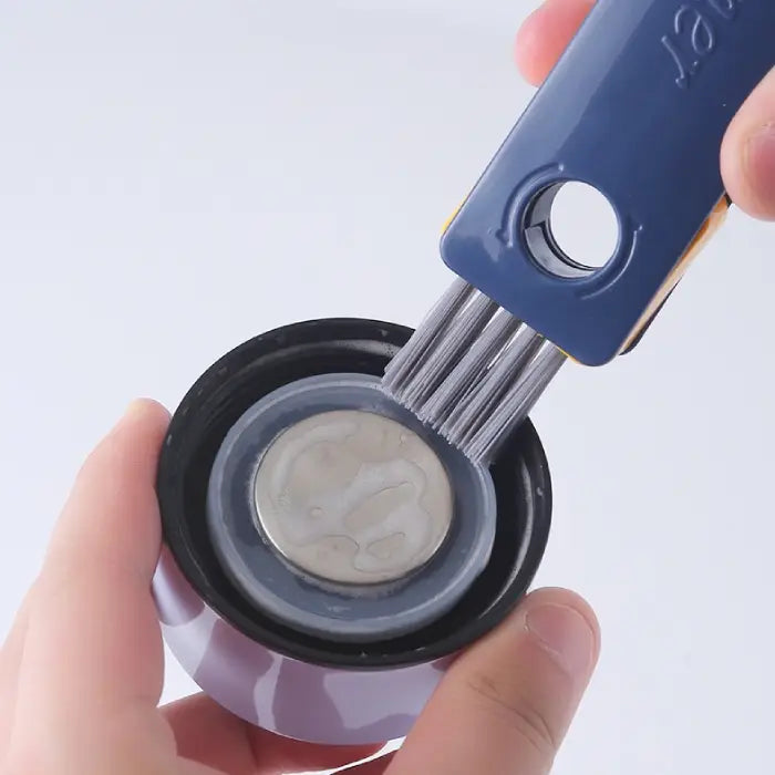 Cleaning brush being used to clean inside a black bottle cap with detailed bristle view