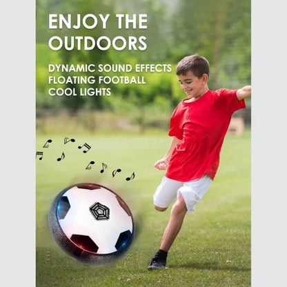 A boy in a red shirt playing with a floating football toy outdoors, featuring sound effects and colorful lights.