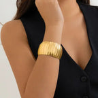 bracelet fashionable ridged gold wide bangle worn with black vest
