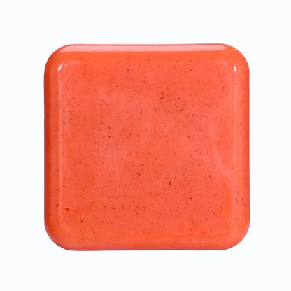 Bright orange exfoliating scrub soap bar isolated on white background.