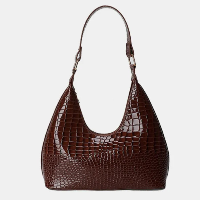 Brown crocodile-embossed leather handbag with single curved handle and shiny textured surface