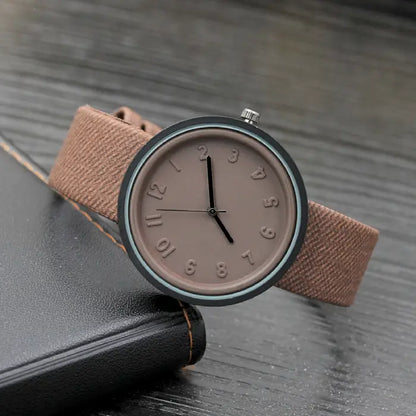 Brown minimalist wristwatch with subtle textured strap and sleek design for a classic, modern look.