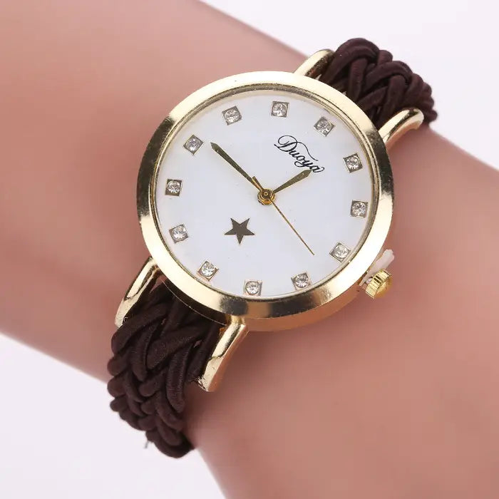 Women's watch with a gold case, white dial, and brown braided rope band.