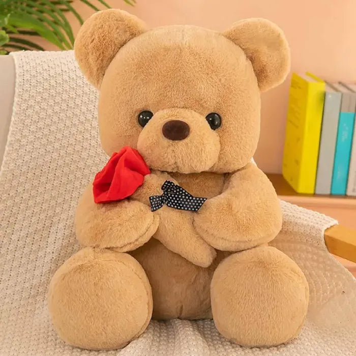 Cuddly brown teddy bear with polka dot bow holding a vibrant red rose.