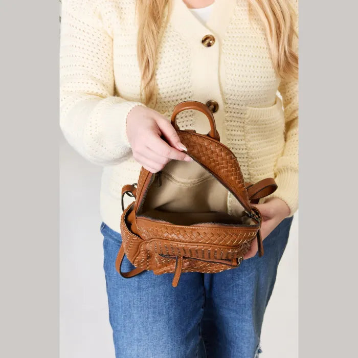  Open view of brown woven leather backpack with spacious interior and organized compartments.