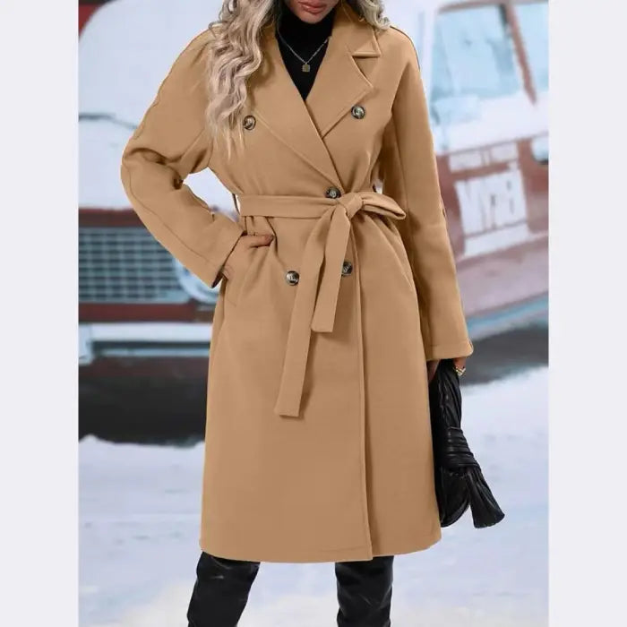 Stylish camel double-breasted trench coat with belt tie, worn with black turtleneck and accessories in winter setting