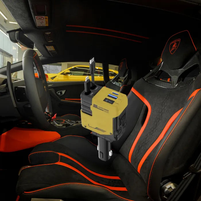 Car charger inside Lamborghini with black and orange interior and yellow sports car visible outside window.
