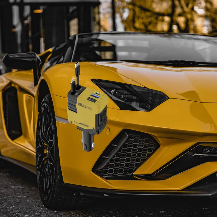 Car charger attached to yellow Lamborghini front exterior with black wheels and blurred background trees.