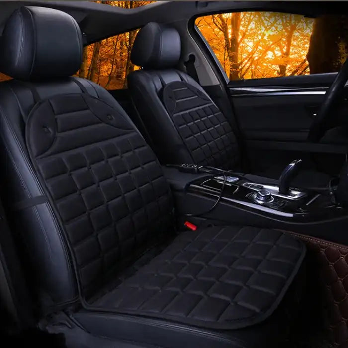 Car Seat Heater black quilted pads on dark car interior with warm lighting.