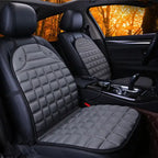 Car Seat Heater grey quilted pads on both front seats in dark interior with warm lighting.