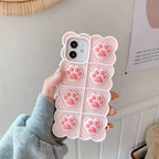 Cat paw phone case in soft pink silicone with 3D raised paw prints featuring detailed toe beans and protective iPhone housing