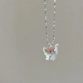 Cat Pendant Necklace featuring single iridescent cat pendant with pink gemstone bow