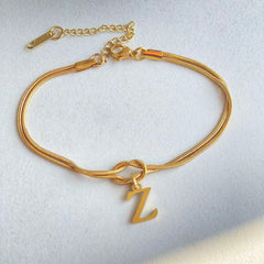 Gold bracelet with a 'Z' charm on a light gray background