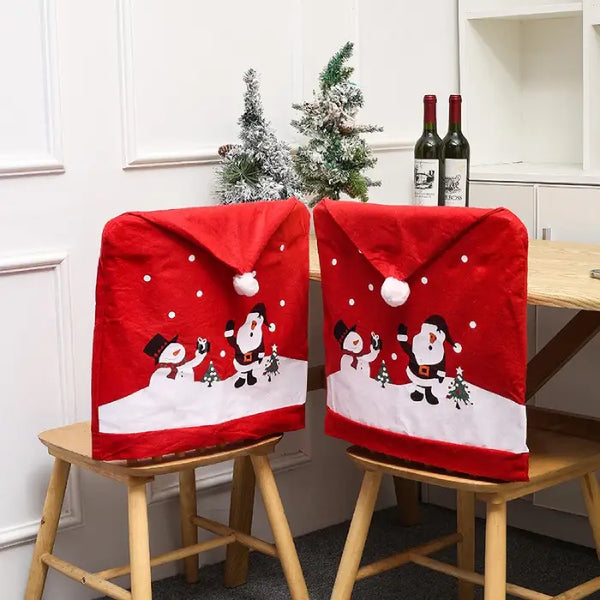 Chair covers with Santa and snowman in red festive design on wooden chairs with Christmas decor.