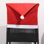 Solid red Santa hat shaped chair cover with white trim and pom-pom displayed on a mesh black chair.
