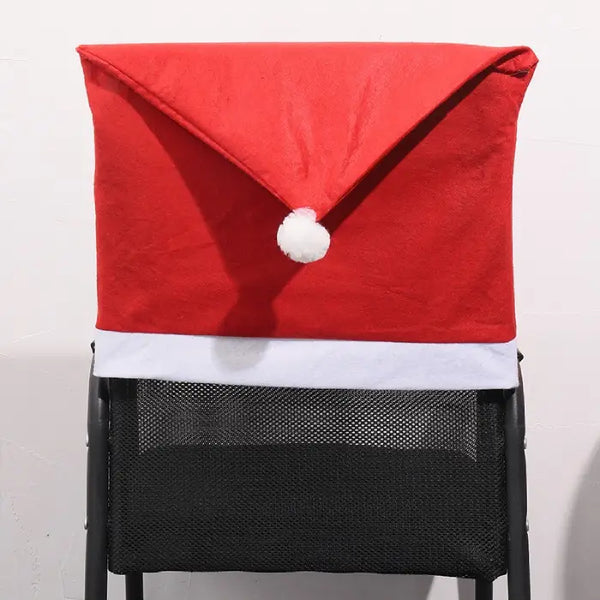Solid red Santa hat shaped chair cover with white trim and pom-pom displayed on a mesh black chair.