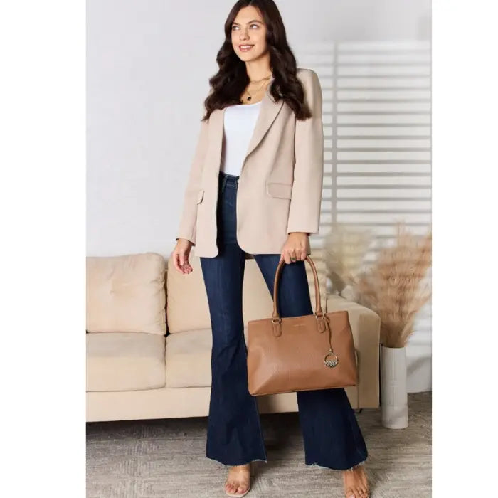 Chic woman stands with brown leather handbag, blending style and function.