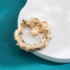 Back view of Christmas brooch showing gold-tone metal clip and textured finish of holly wreath