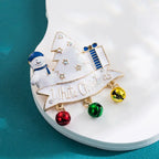 Christmas brooch with white tree, snowman, presents, and colorful jingle bells labeled White Christmas