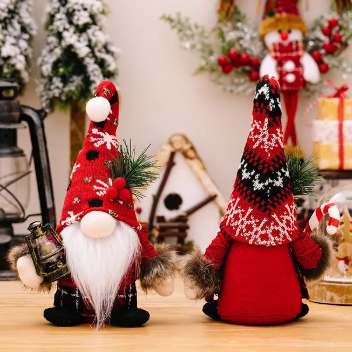 Two decorative Christmas gnomes with unique red hat patterns, displayed with holiday ornaments, pine sprigs, and a wooden birdhouse