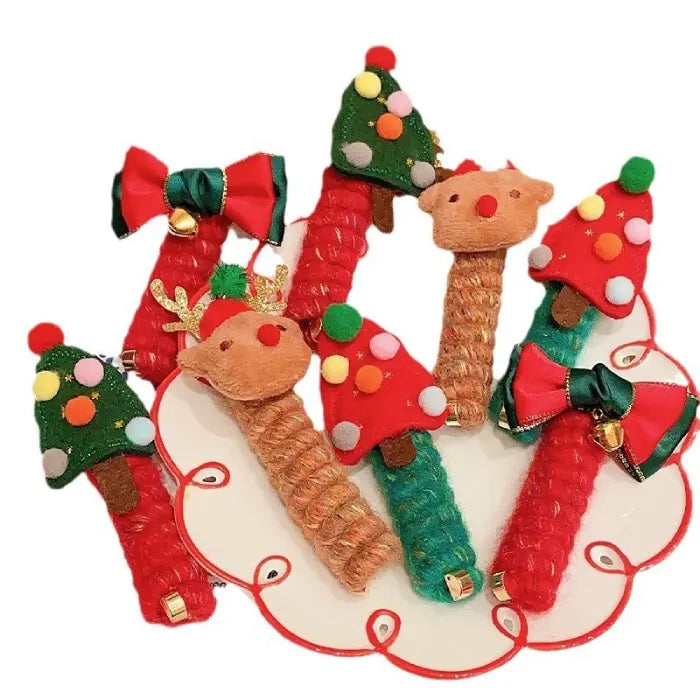 Set of Christmas hair ropes with red bows, reindeer, and tree designs displayed on a festive plate.