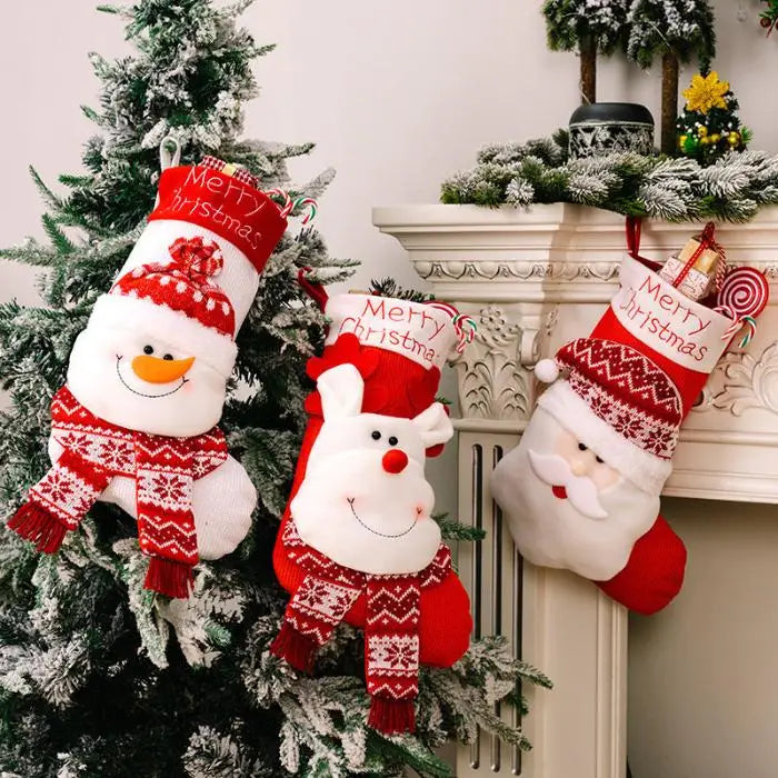 Three Christmas stockings with Santa, snowman, and reindeer designs hanging on ornate white fireplace mantel with holiday decorations