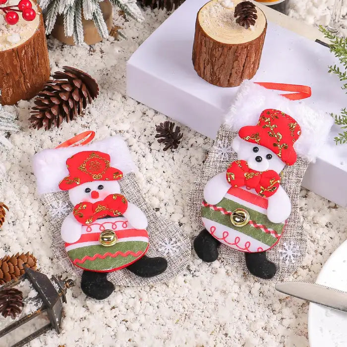 Christmas stockings with two snowman designs featuring red hats and bowties on snowy holiday background.