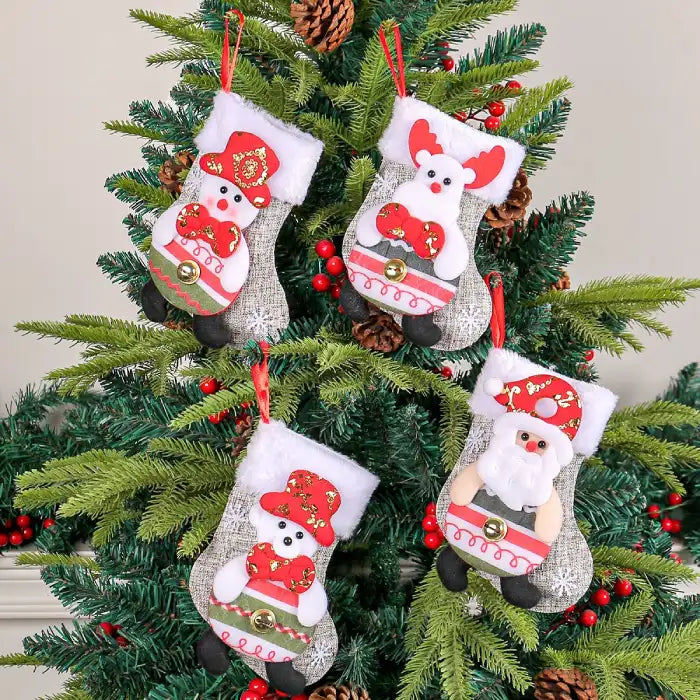 Christmas stockings hanging on Christmas tree featuring plush Santa, snowman, bear, and reindeer characters.