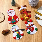 christmas table decorations with assorted felt santa snowman and reindeer cutlery holders on wooden table