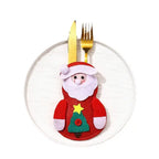 christmas table decorations showing a felt santa cutlery pocket holding gold fork and knife