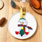 christmas table decorations with a felt snowman cutlery pocket on a white plate