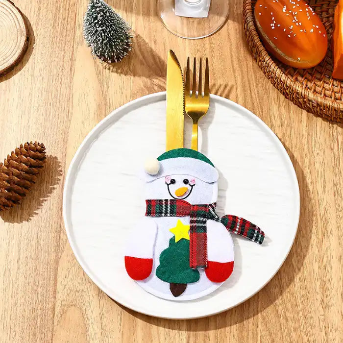 christmas table decorations with a felt snowman cutlery pocket on a white plate