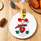 christmas table decorations featuring a snowman cutlery holder with red heart and plaid scarf