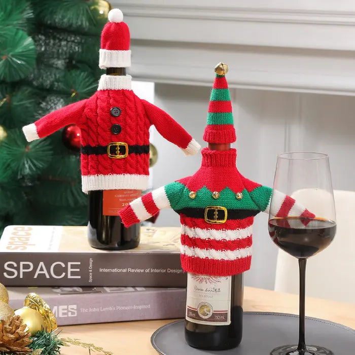 Wine bottle dressed in holiday sweater covers near design books and Christmas decorations for festive entertaining