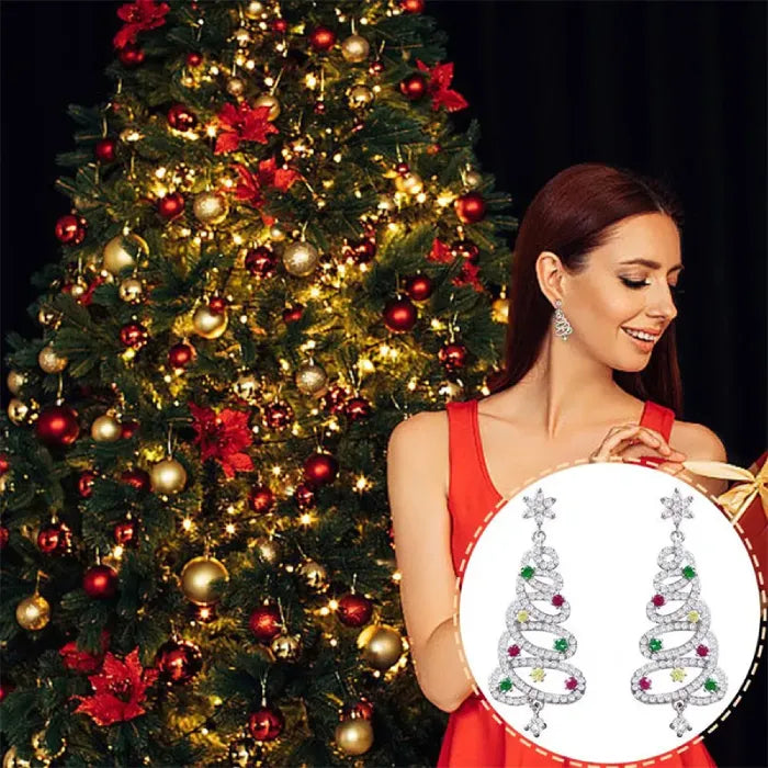 Christmas tree earrings with gemstones, styled in a festive holiday setting featuring a decorated tree.