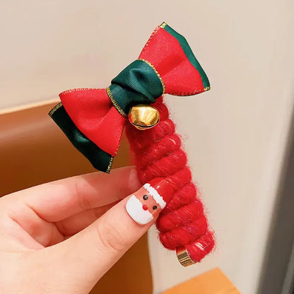 Close-up of Christmas tree hair rope with red and green festive design and colorful pom-poms.