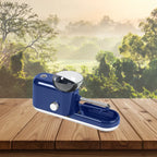 Cigarette Rolling Machine in dark blue displayed on wooden deck with forest background and sunrise.