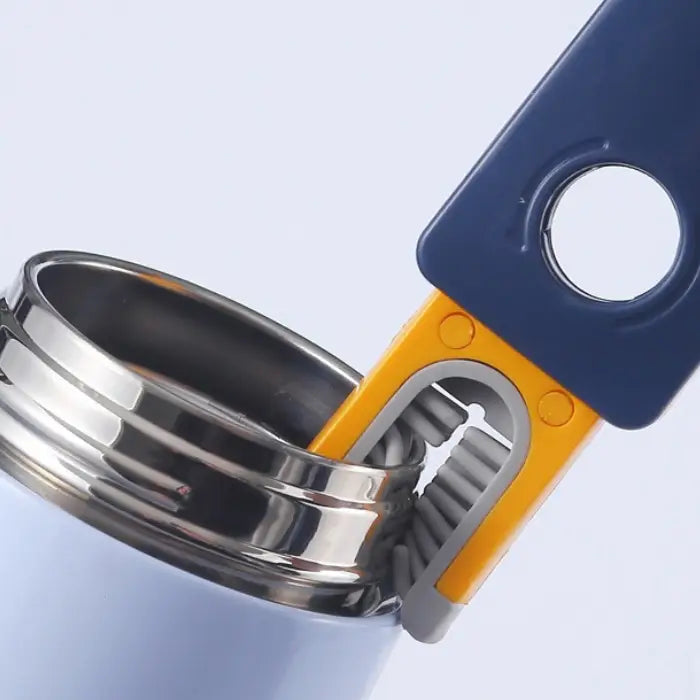 Close-up of cleaning brush bristles being used to clean inside a metal container lid