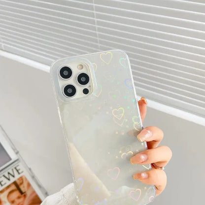 Hand holding a clear phone case with holographic heart accents, perfect for stylish phone protection.